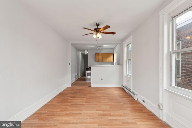 unfurnished living room featuring light wood-type flooring, baseboards, a baseboard heating unit, and a wealth of natural light