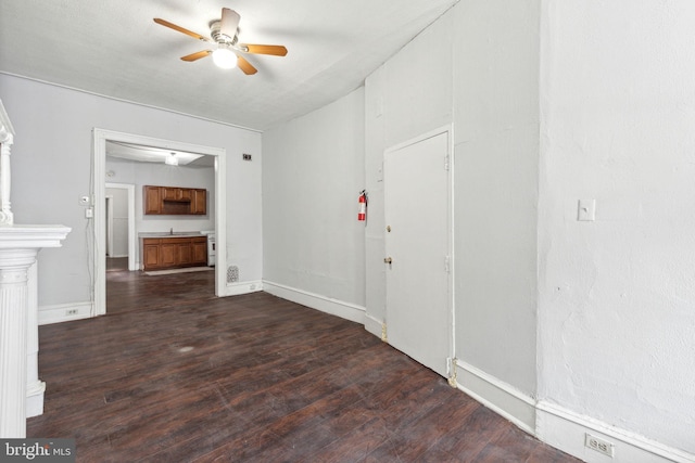 interior space featuring ceiling fan, baseboards, and dark wood-type flooring