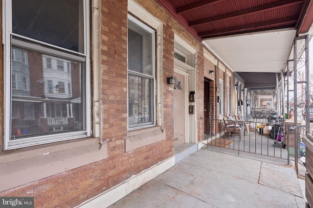 exterior space with covered porch and brick siding