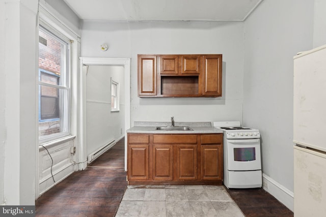 kitchen with a baseboard heating unit, white appliances, a sink, light wood-style floors, and brown cabinetry