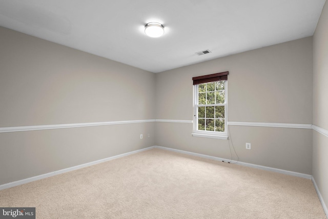 unfurnished room featuring carpet, visible vents, and baseboards