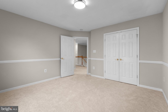 unfurnished bedroom with a closet, carpet flooring, and baseboards