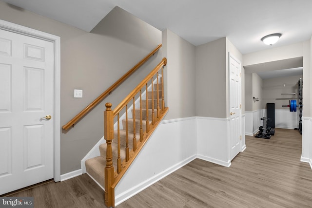 staircase featuring baseboards and wood finished floors