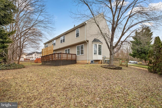 back of property with fence and a wooden deck