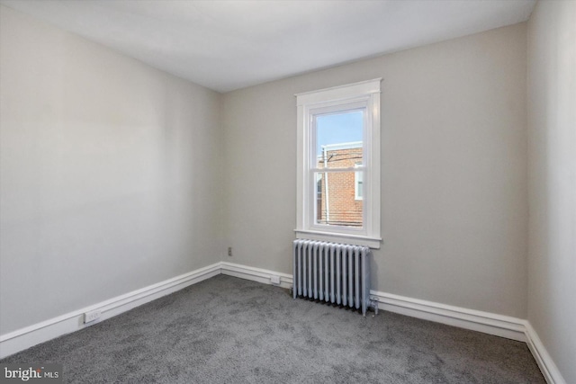 carpeted spare room with radiator and baseboards