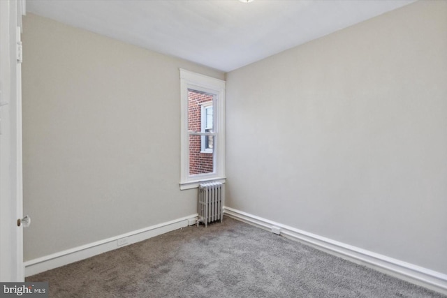 carpeted spare room with radiator and baseboards