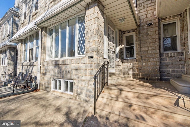 doorway to property featuring stone siding