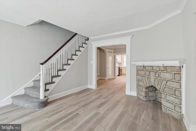 stairway featuring crown molding, baseboards, and wood finished floors