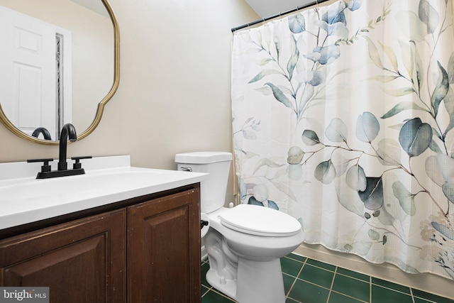 bathroom with toilet, vanity, and tile patterned floors