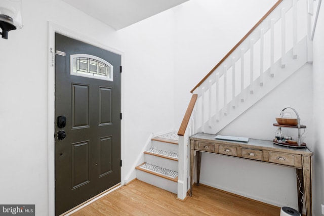 entryway with stairway, light wood-style flooring, and baseboards