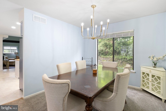 dining space with carpet, visible vents, a chandelier, and baseboards