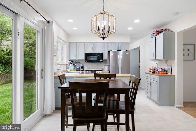 dining area with recessed lighting and an inviting chandelier