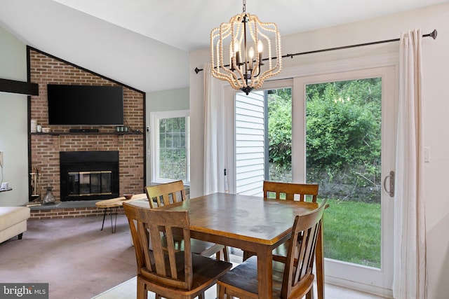 carpeted dining area featuring a chandelier, a brick fireplace, and vaulted ceiling