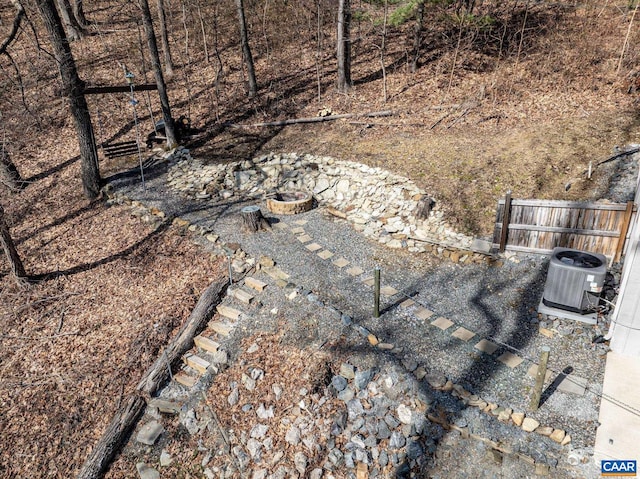 exterior details with cooling unit, a fire pit, and fence