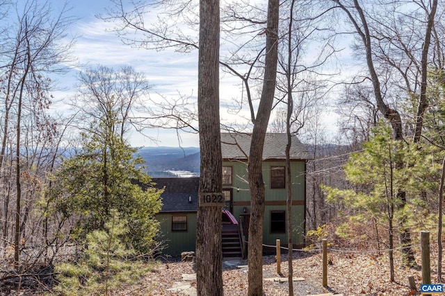 back of property with stairway and roof with shingles