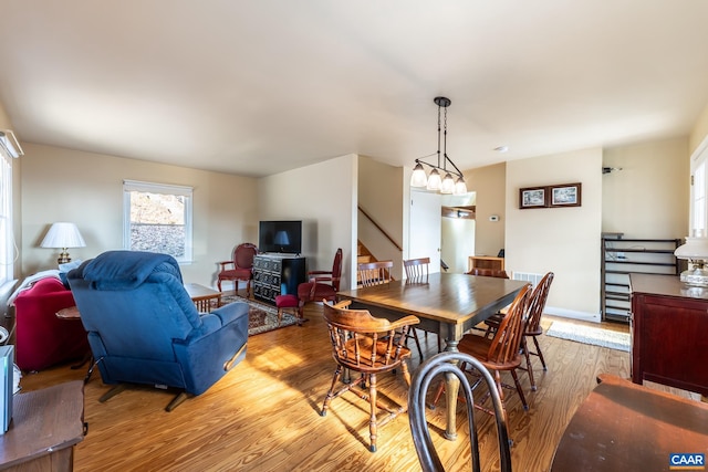 dining room featuring stairway, light wood-style flooring, and baseboards