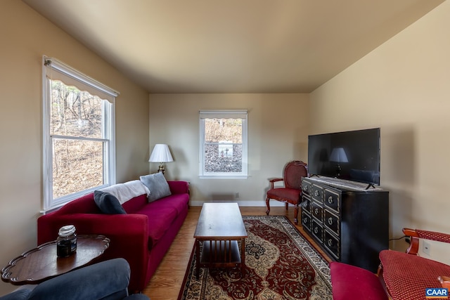 living area with baseboards and wood finished floors