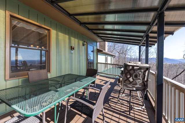 wooden deck featuring outdoor dining area and a mountain view