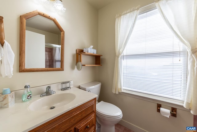 bathroom featuring toilet, plenty of natural light, and vanity