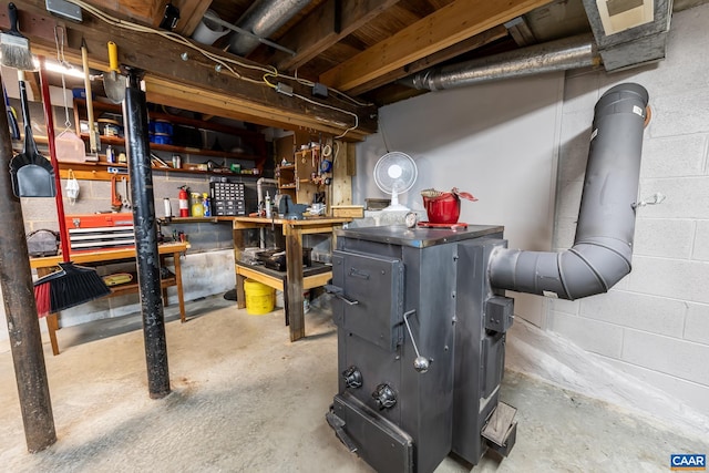 unfinished basement featuring a workshop area and concrete block wall