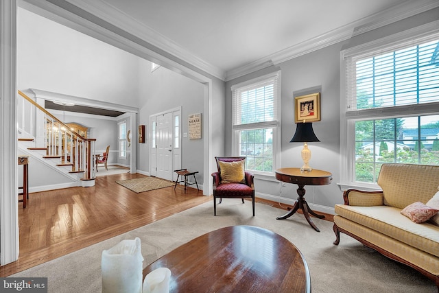 interior space featuring crown molding, stairway, baseboards, and wood finished floors