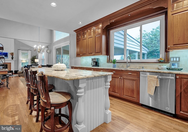 kitchen with brown cabinets, a kitchen breakfast bar, and stainless steel dishwasher