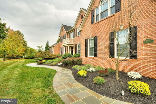 view of side of home featuring a yard and brick siding