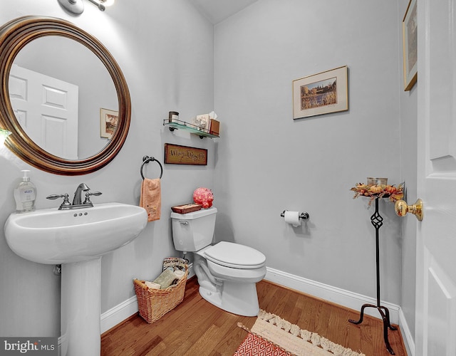 bathroom featuring wood finished floors, toilet, and baseboards