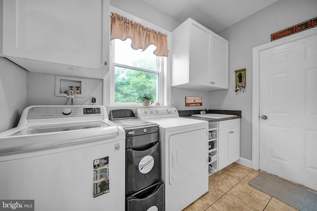 clothes washing area featuring cabinet space, separate washer and dryer, a sink, and light tile patterned flooring