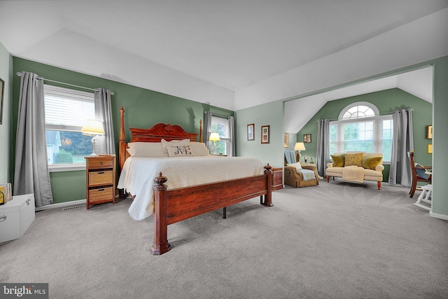 carpeted bedroom featuring multiple windows, vaulted ceiling, visible vents, and baseboards