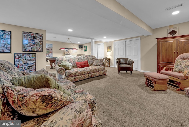 carpeted living area featuring baseboards, visible vents, and recessed lighting