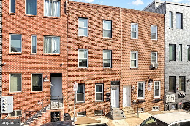 view of building exterior with entry steps and cooling unit