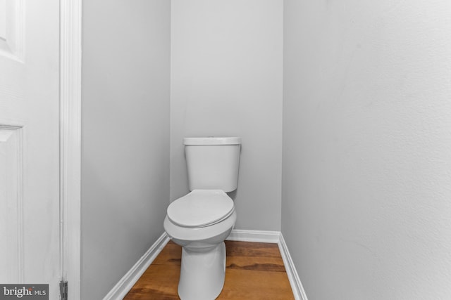 bathroom featuring toilet, baseboards, and wood finished floors