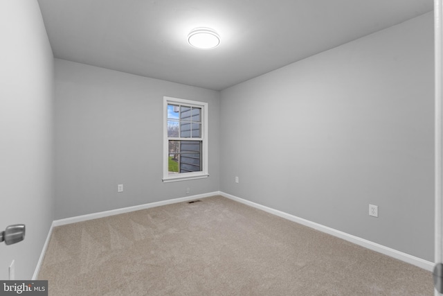 carpeted empty room with visible vents and baseboards