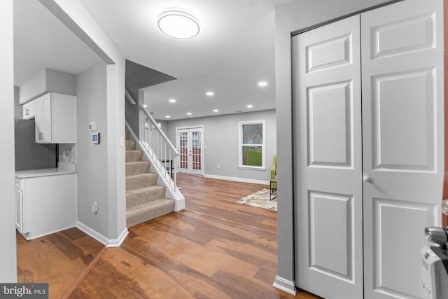 entryway with stairs, baseboards, wood finished floors, and recessed lighting