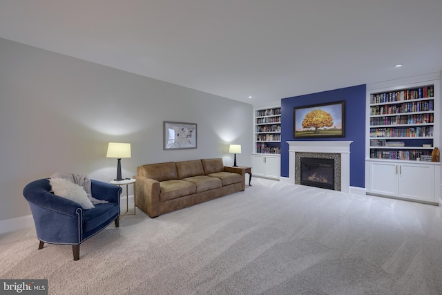 carpeted living area with a glass covered fireplace, built in features, recessed lighting, and baseboards