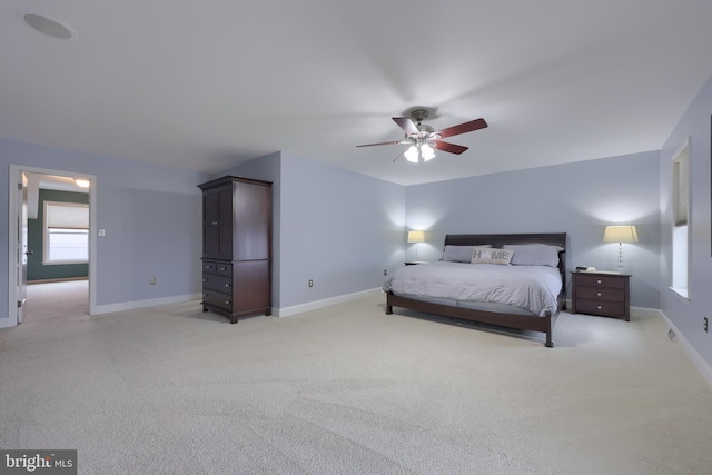 bedroom with light carpet, a ceiling fan, and baseboards