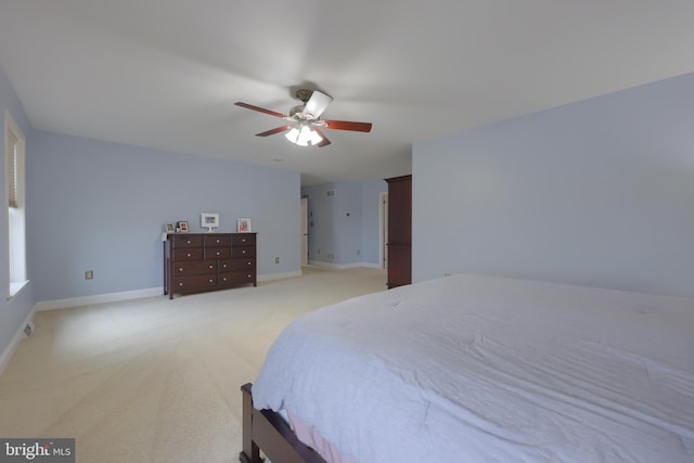 bedroom featuring light carpet, ceiling fan, and baseboards