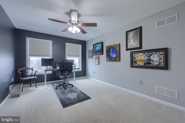 carpeted office space featuring baseboards, visible vents, and ceiling fan