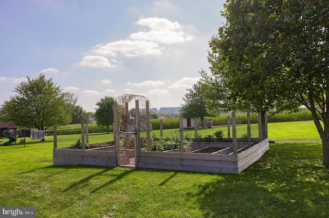 view of home's community featuring a vegetable garden, a yard, and playground community