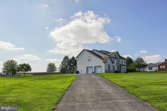 view of front facade featuring a garage, stone siding, a front yard, and driveway