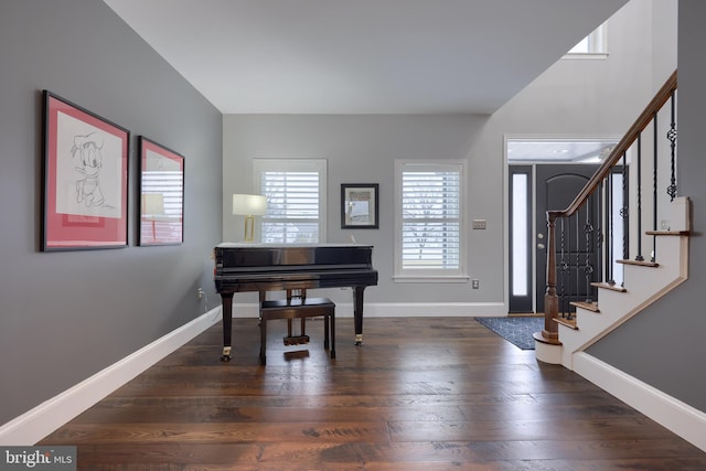 foyer with dark wood-type flooring, stairway, and baseboards