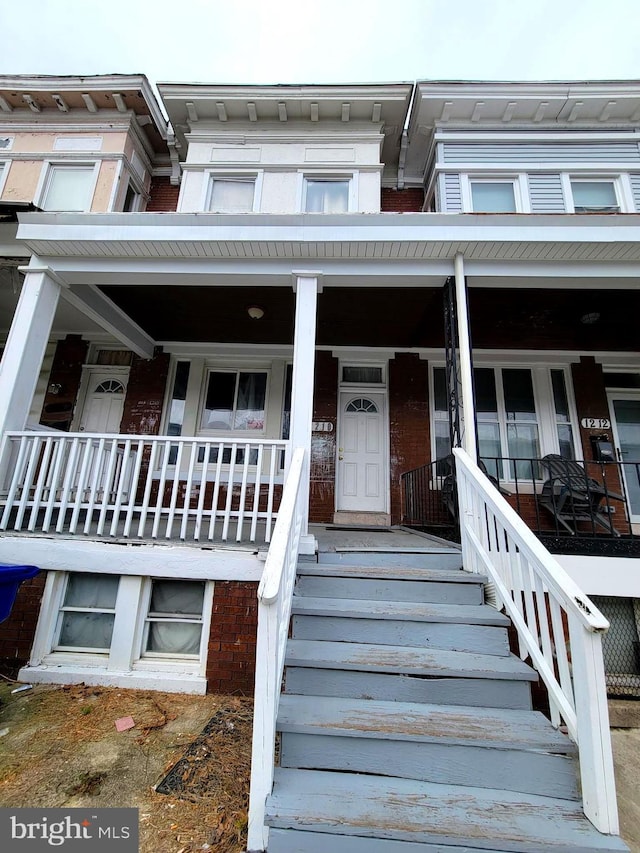 view of front of house with covered porch and brick siding