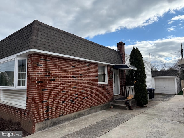 view of property exterior featuring roof with shingles, brick siding, and mansard roof