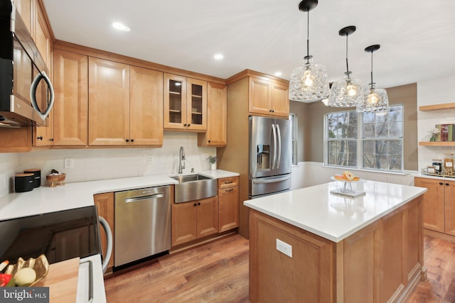 kitchen with stainless steel appliances, light wood-type flooring, a sink, and backsplash