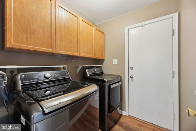 laundry room with wood finished floors, cabinet space, and separate washer and dryer