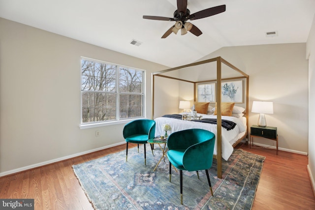 bedroom with lofted ceiling, baseboards, visible vents, and wood finished floors