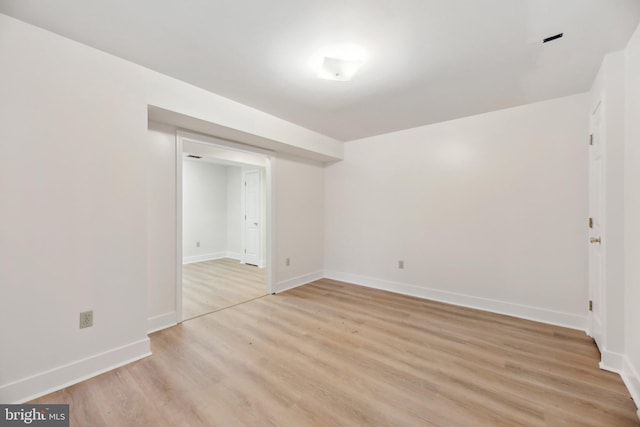 unfurnished room featuring baseboards and light wood finished floors