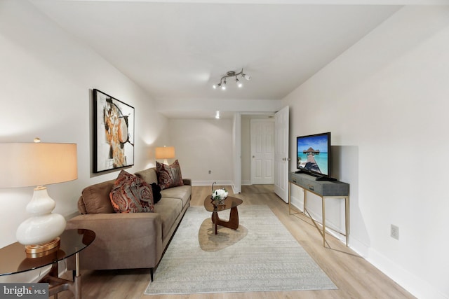 living area with light wood-style flooring and baseboards