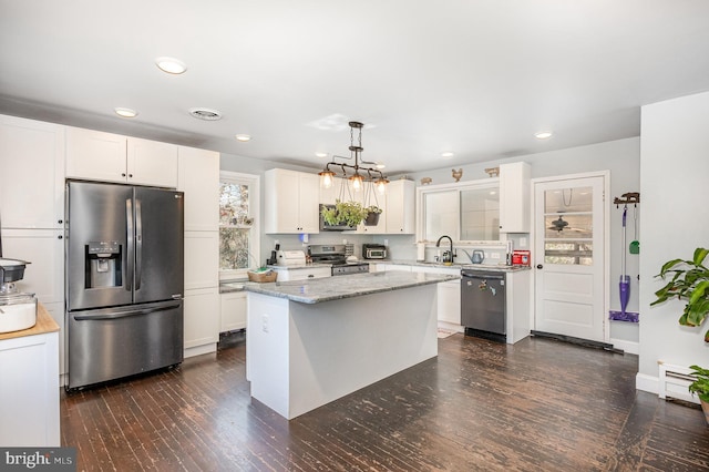 kitchen featuring dark wood finished floors, white cabinets, pendant lighting, and stainless steel appliances